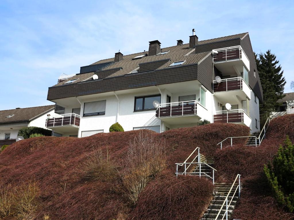 ein weißes Apartmenthaus auf einem Hügel in der Unterkunft Apartment Hillebachsee in Winterberg