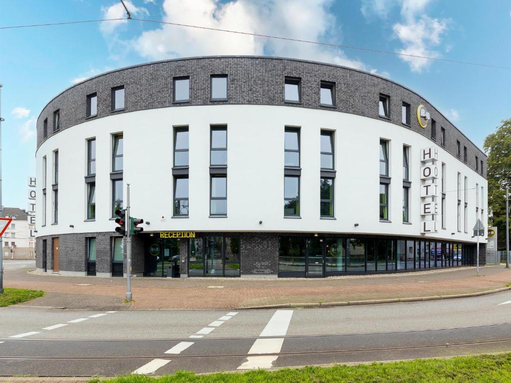 ein weißes Gebäude an der Ecke einer Straße in der Unterkunft B&B Hotel Krefeld in Krefeld