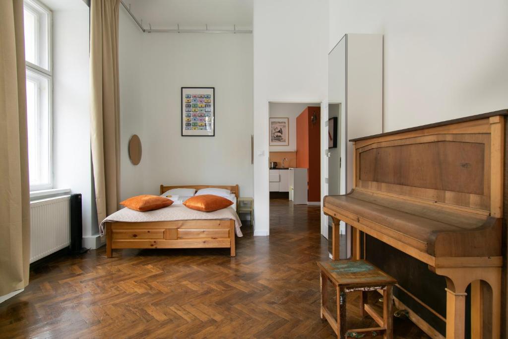 een slaapkamer met een bed en een piano bij Apartments Studencka Street, Next to Planty Park in Krakau