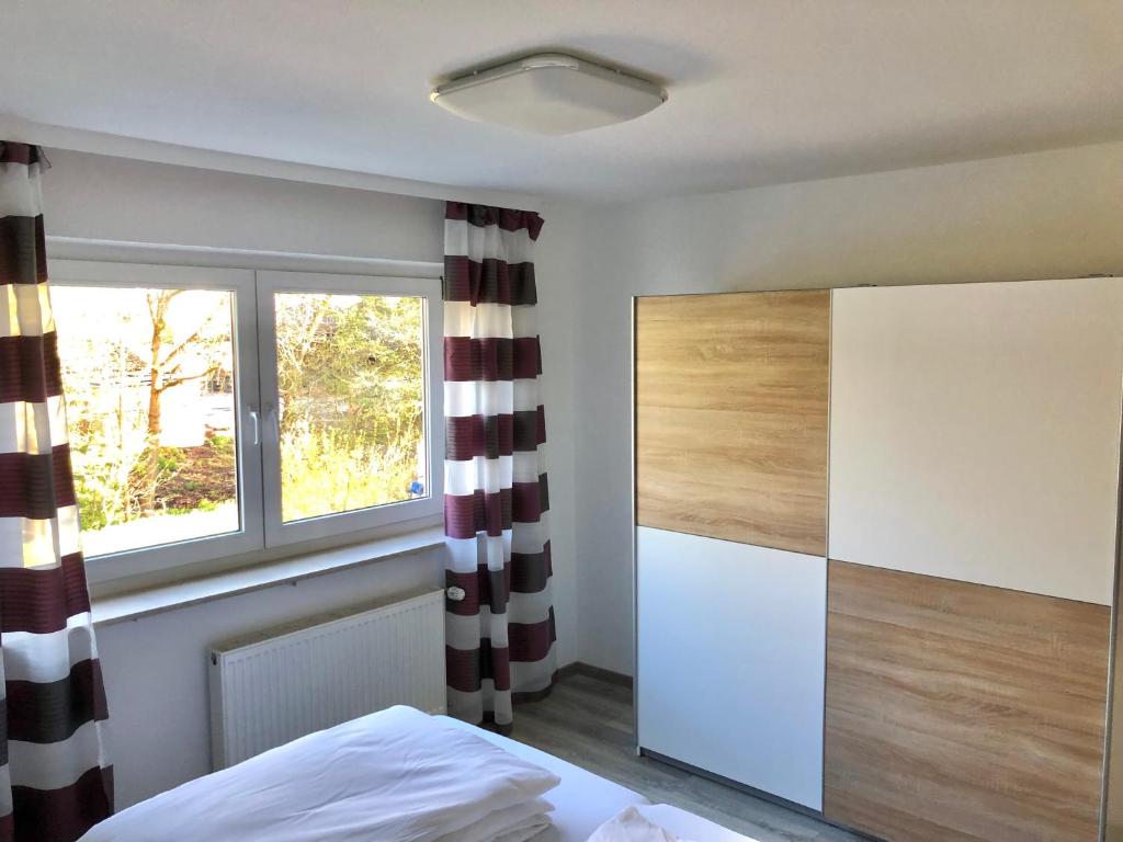 um quarto com uma cama e uma janela em Schöne Ferienwohnung direkt am Neckar em Deißlingen