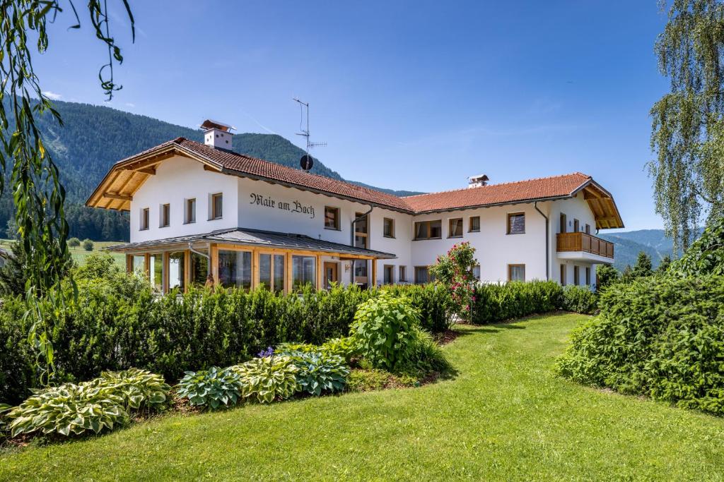 an exterior view of a house with a garden at Ferienwohnung Mair am Bach in Brunico