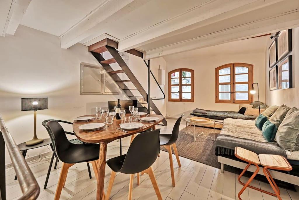 un salon avec une table, des chaises et un canapé dans l'établissement La Bulle - Parking Gratuit en souterrain - 2 mins du Palais des Papes - CLIM AC - Wifi, à Avignon