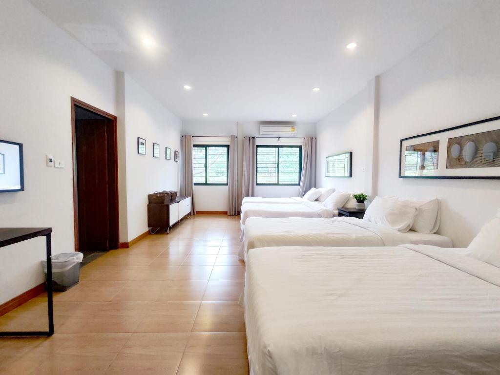ムーシにあるThe White Chalet Khaoyaiの広い客室で、ベッド3台が備わります。