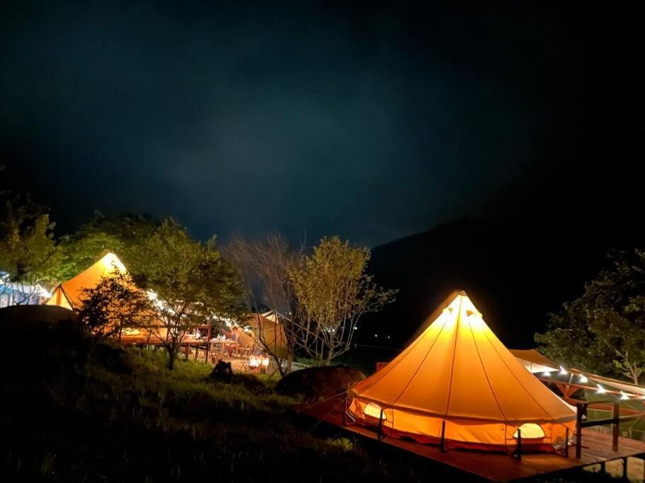 ties Camp Ground Nagiso في ناغيسو: مجموعة من الخيام في حقل ليلا