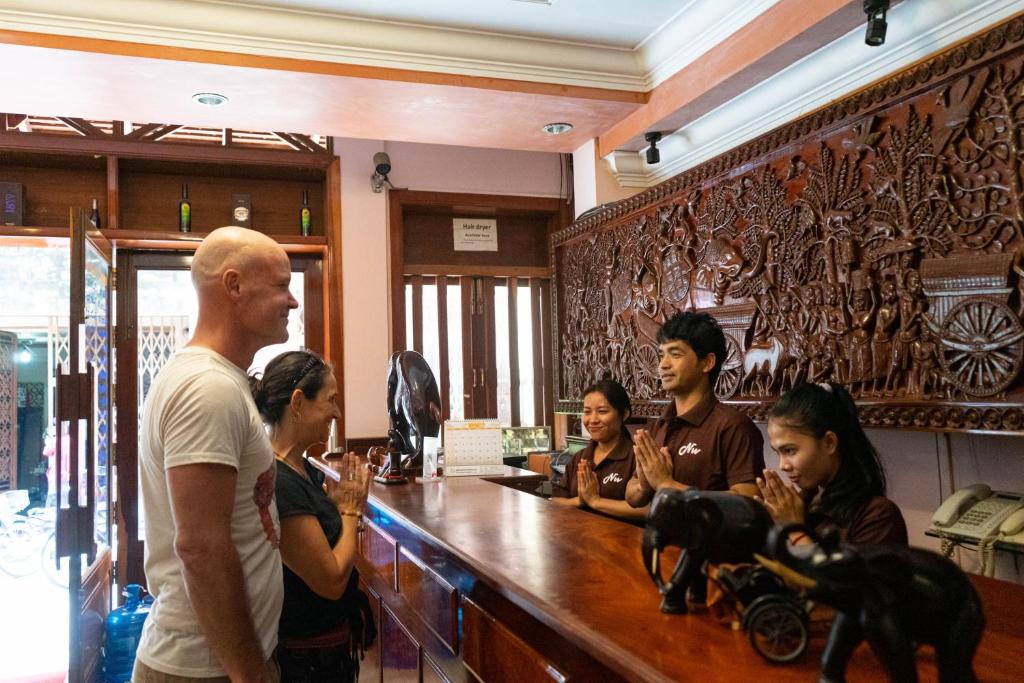 Un groupe de personnes autour d'un bar dans l'établissement Nawin Palace Guesthouse, à Phnom Penh