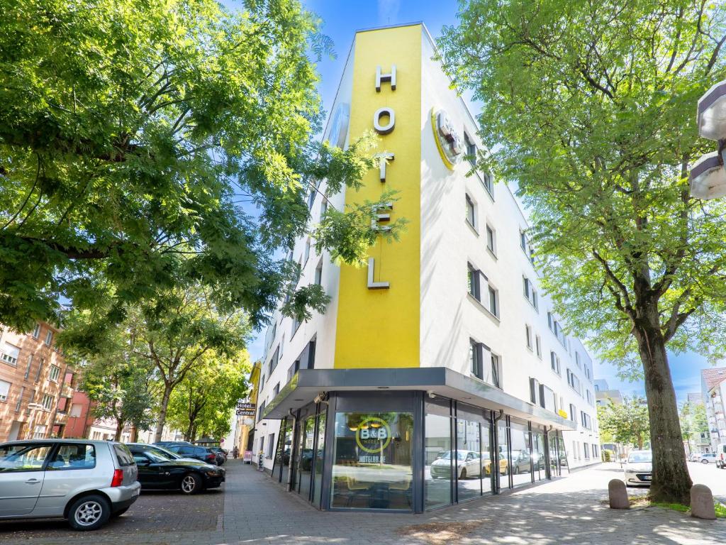um edifício amarelo e branco numa rua da cidade em B&B Hotel Heilbronn em Heilbronn