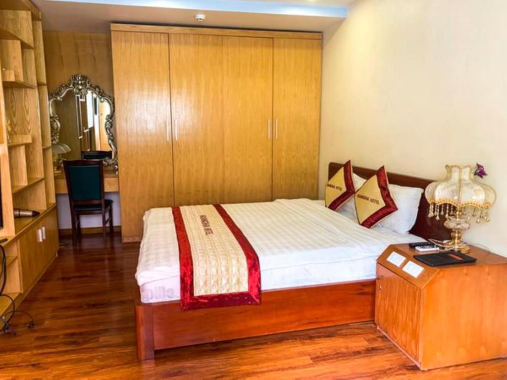 1 dormitorio con 1 cama y armario de madera en Hoàng Hà Hotel Tam Đảo en Tam Ðảo