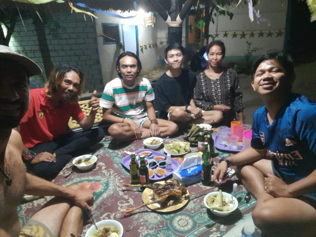 a group of people sitting around a table eating food at SUNRISE BUKIT ASAM HOMESTAY in Kuta Lombok