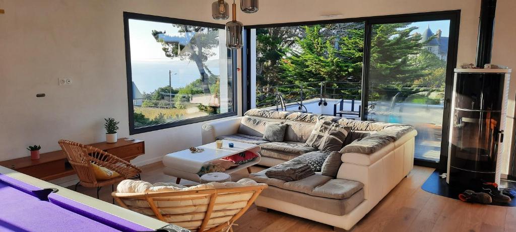 a living room with a couch and a large window at Villa face à la mer in Binic