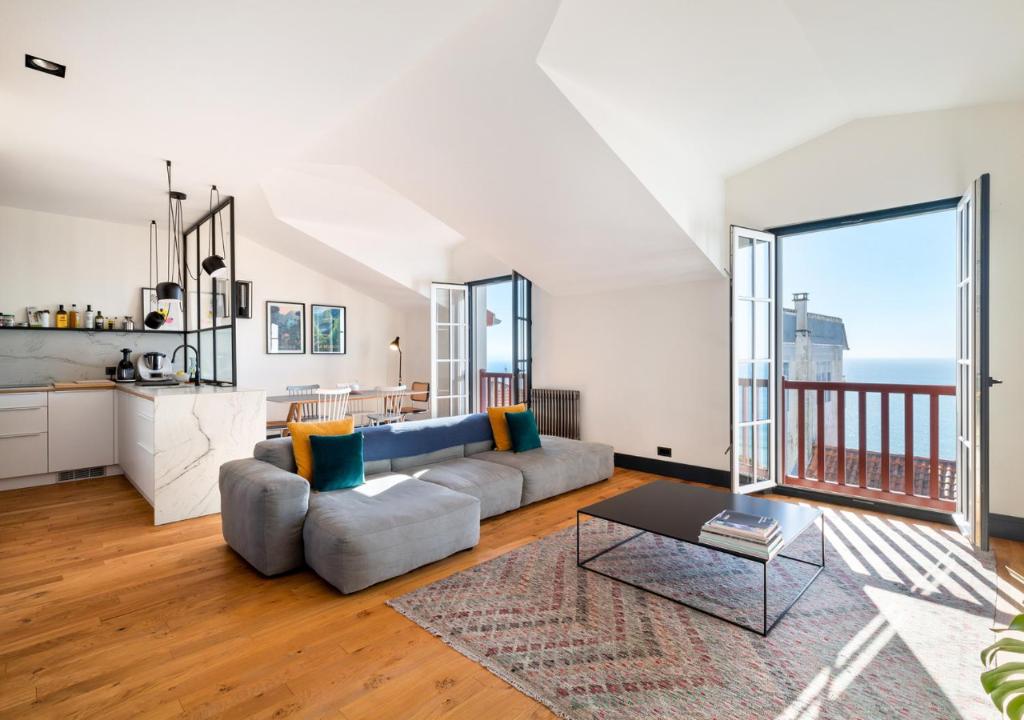 un salon avec un canapé et une table dans l'établissement Appartement avec vue sur la côte des Basques By Ginto Hotels, à Biarritz