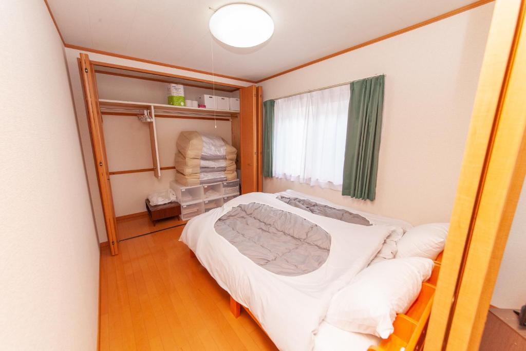 a hospital room with a bed and a mirror at Restful Tsukuda in Aomori