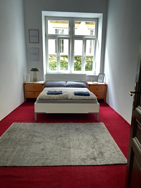 um quarto com uma cama e uma grande janela em City Apartment and rooms em Viena