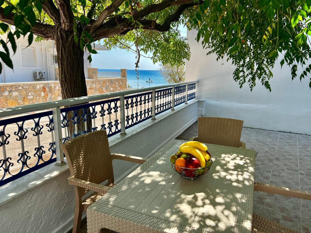 a bowl of fruit sitting on a table with a tree at Stella Beach House in Archangelos