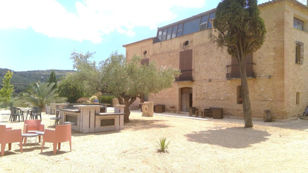 un edificio con tavoli e sedie di fronte ad esso di La Bodega Enoturismo Rural a Mogente