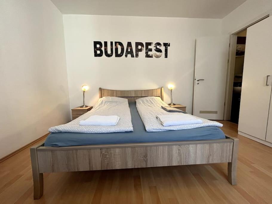 een bed in een kamer met een bord aan de muur bij Garay Utca - Unit A52 in Boedapest