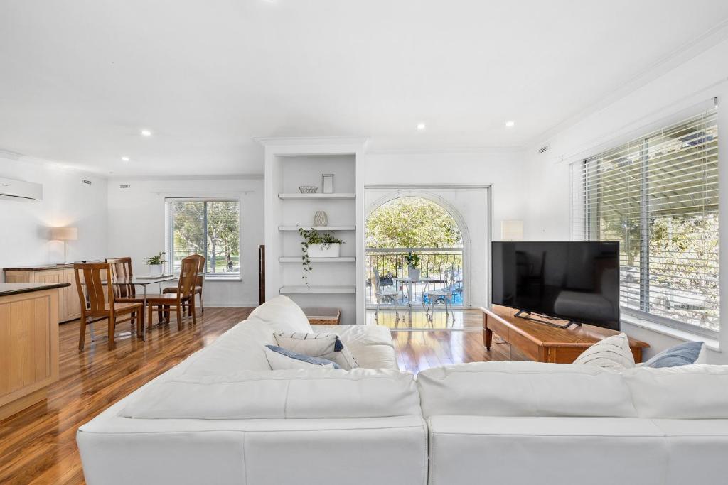 a living room with a white couch and a tv at 10/17 Richardson Street, South Perth in Perth