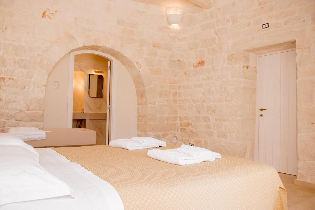 2 Betten in einem Zimmer mit einer Steinmauer in der Unterkunft Trullo Cinquenoci Suite in Locorotondo