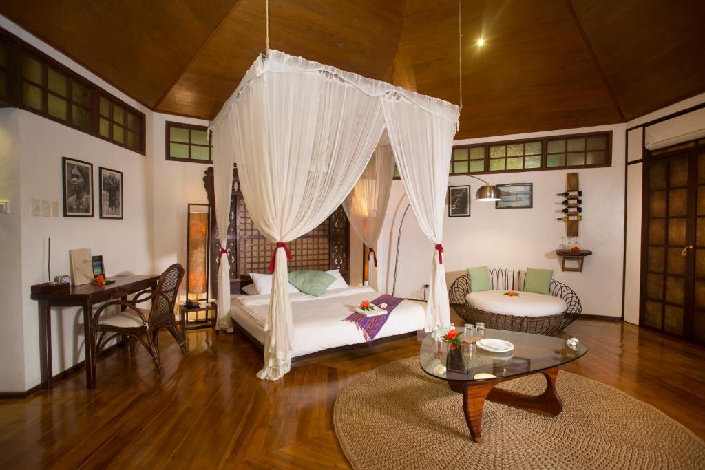 Sala de estar con cama y mesa en Mandala Spa & Resort Villas, en Boracay