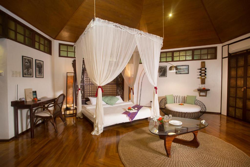 a living room with a bed and a table at Mandala Spa & Resort Villas in Boracay