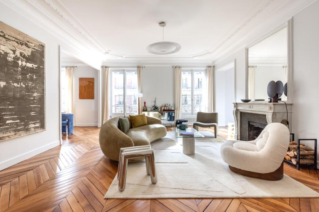 un salon avec deux chaises et une cheminée dans l'établissement Luxury apartment - 5 min walk from Champs-Elysées, à Paris