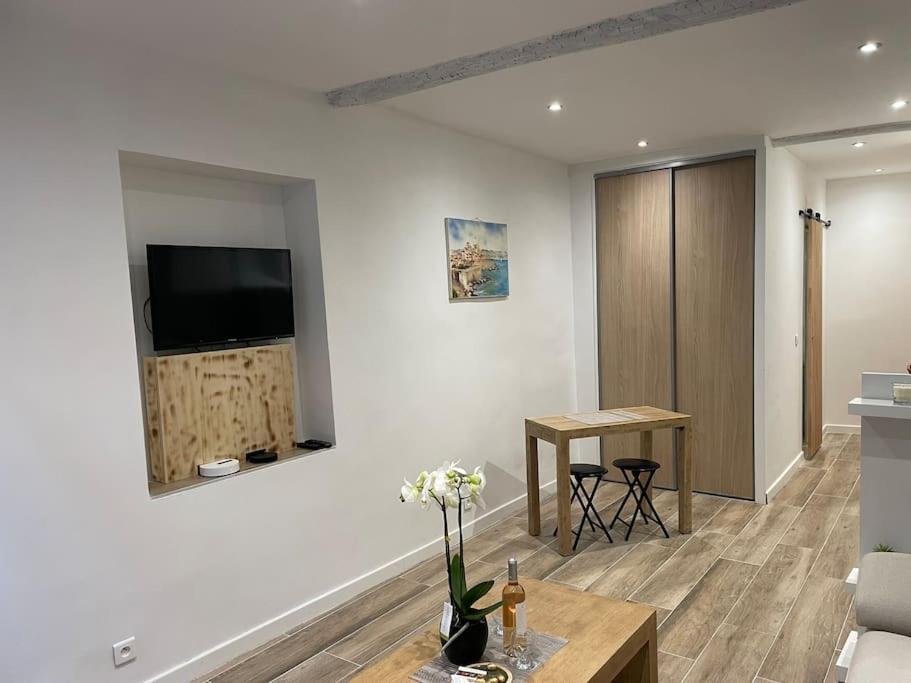 un salon avec une télévision sur un mur dans l'établissement Antibes : Beau studio en plein centre ville, à Antibes