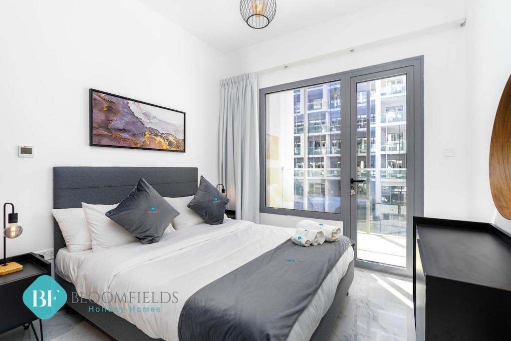 a bedroom with a large bed and a large window at Executive 1 Bedroom In Oasis in Abu Dhabi
