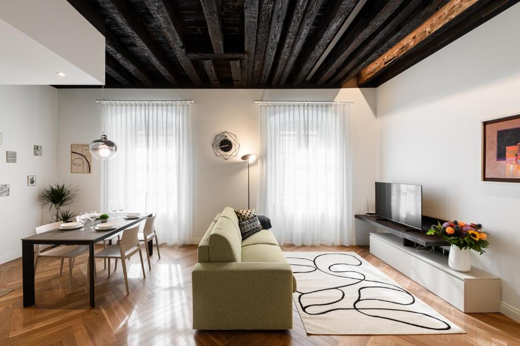 un soggiorno con tavolo, divano e TV di TRIESTinn - Suite Borsa a Trieste