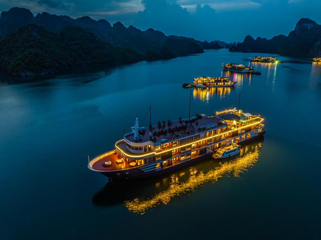 un grand bateau dans l'eau la nuit dans l'établissement Aqua Of The Seas Cruise Halong, à Hạ Long