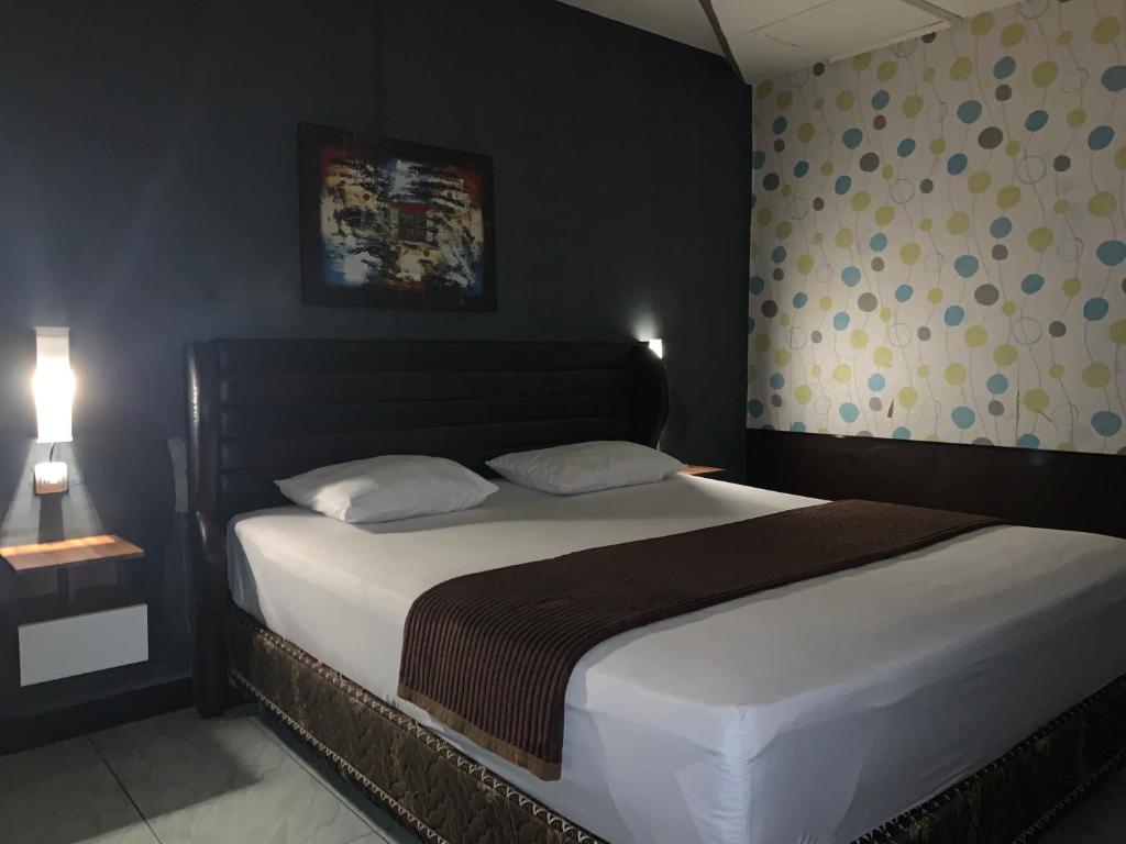 パランカラヤにあるWisma Madagaskar Palangka Rayaのベッドルーム1室(大きな白いベッド1台、枕2つ付)