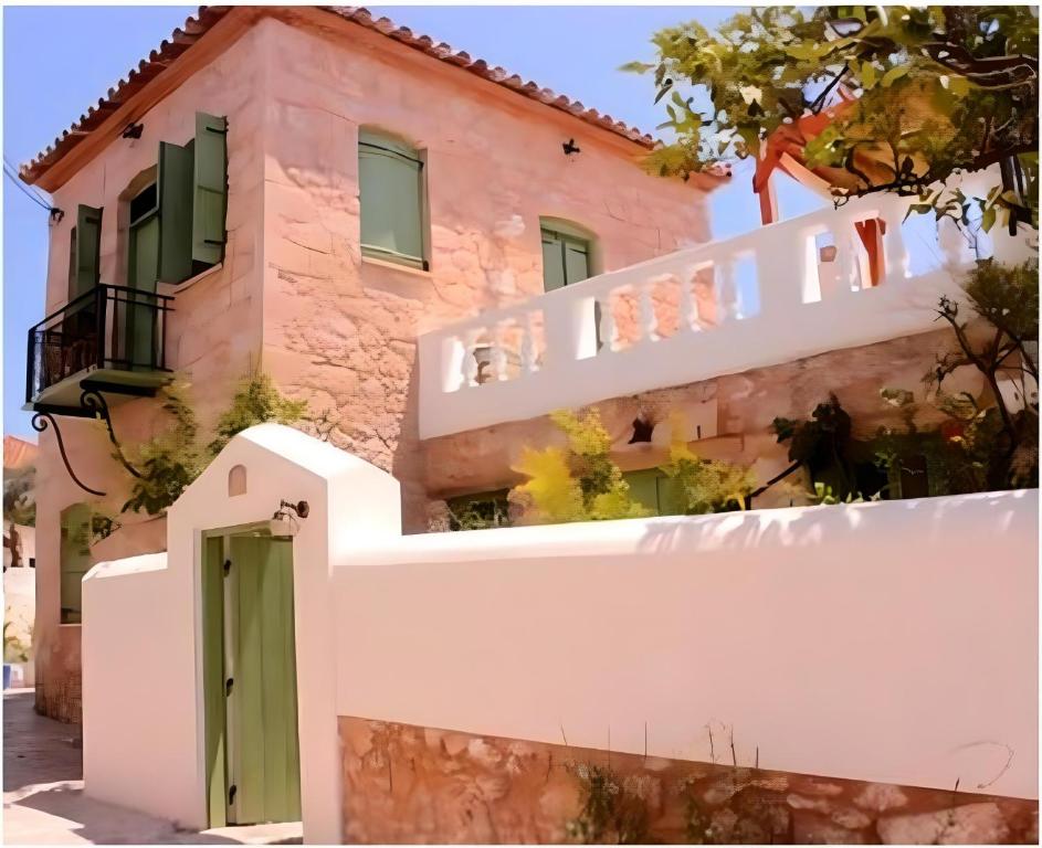 una casa con una recinzione bianca e una porta verde di Artists' Residence 2 bed, 2 bath a Megalochori (Isola di Agistri)
