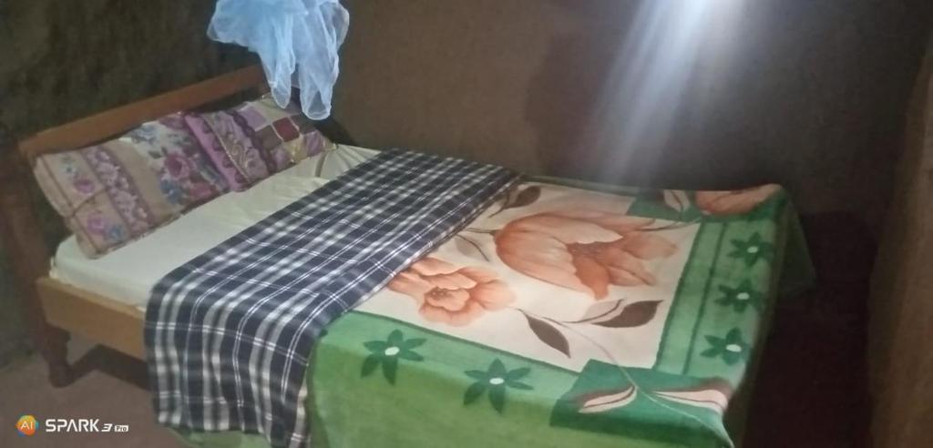 a small bed with a green and white comforter at Nadupa homestay Maasai Mara in Sekenani