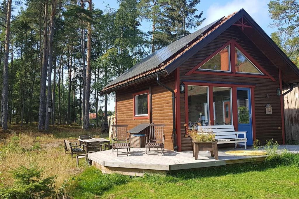 eine kleine Blockhütte mit einem Picknicktisch und Bänken in der Unterkunft Trevligt gästhus nära Vänern och badplats in Hammarö