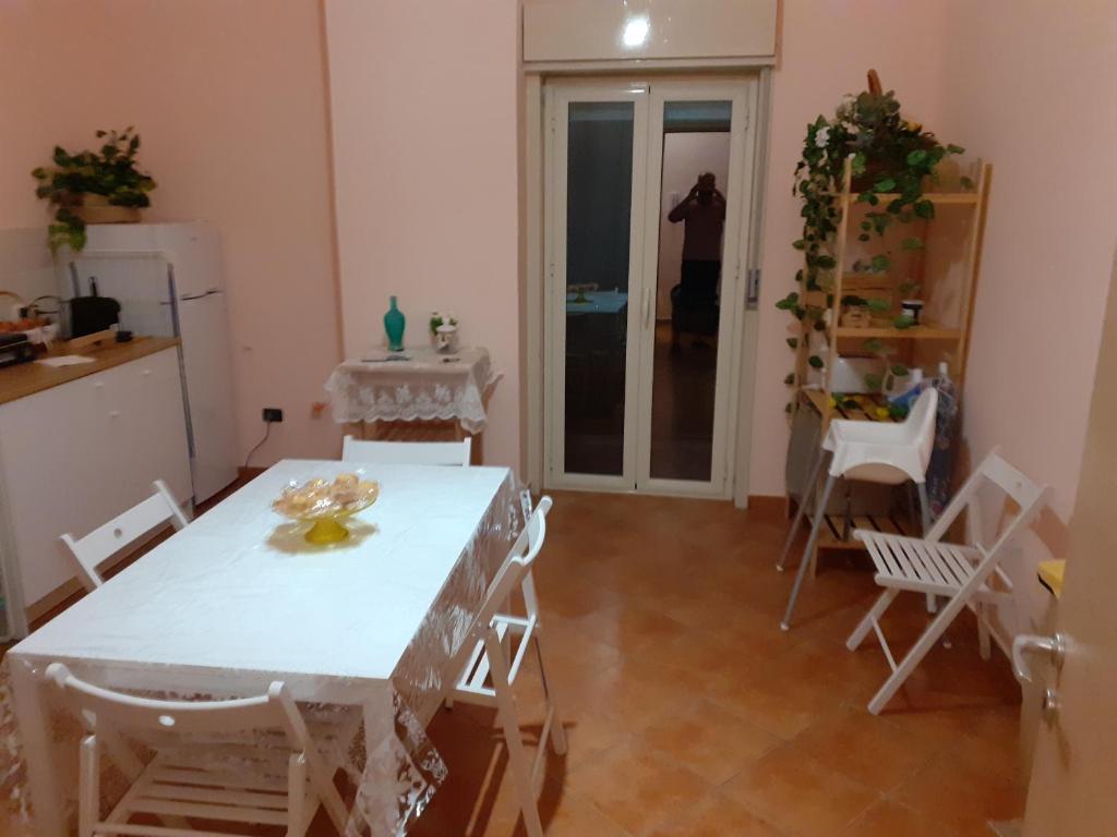 Pokój ze stołem i krzesłami oraz osoba robiąca zdjęcie w obiekcie La Suite dei Ricami w mieście Agrigento