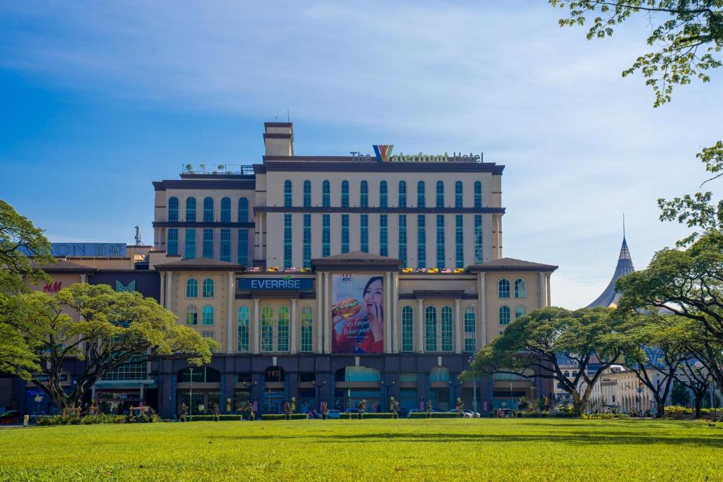 a large building in a park with a green field at The Waterfront Hotel Kuching in Kuching