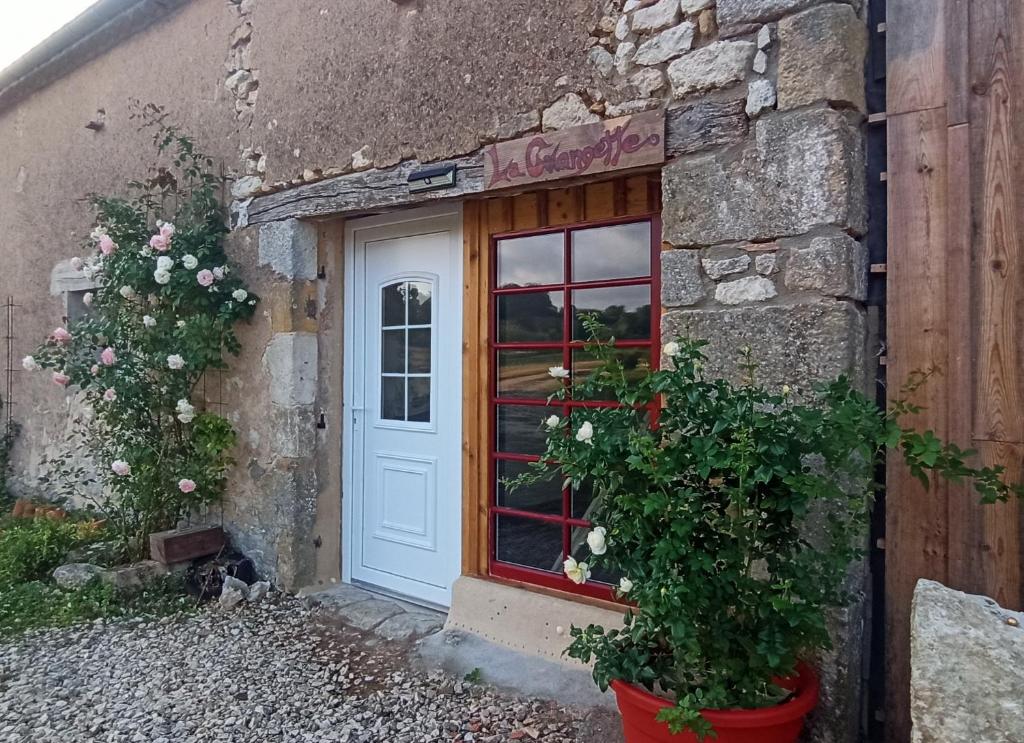 a door of a stone building with flowers in front of it at La Grangette in Saint-Martin-de-Villeréal