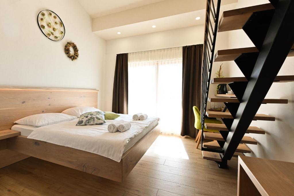 a bedroom with a bed and a spiral staircase at Ferjančič estate rooms in Ajdovščina