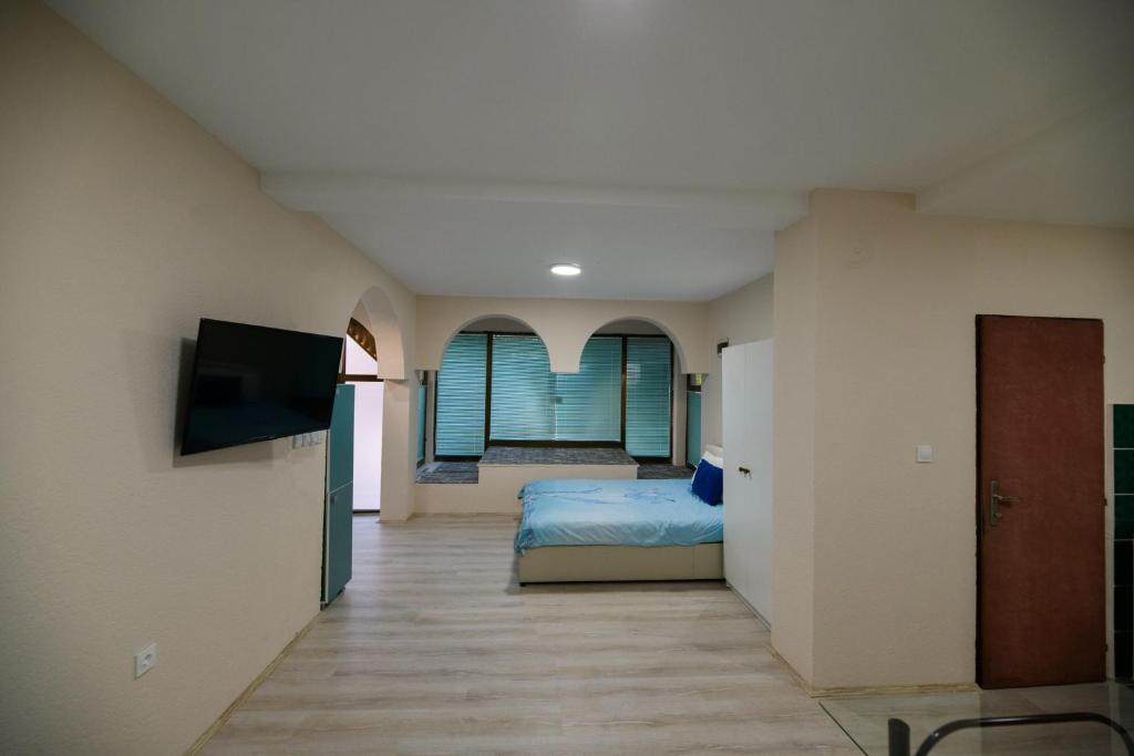 a bedroom with a bed and a flat screen tv at Rose's Apartment in Prilep