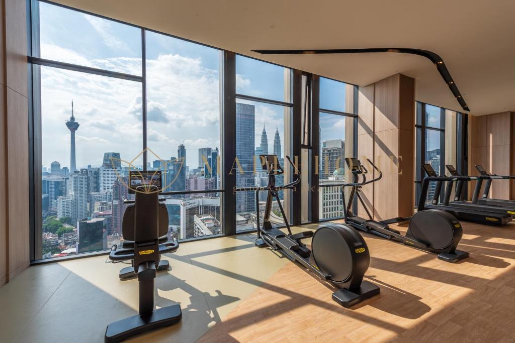 een fitnessruimte met cardio-apparatuur en uitzicht op de stad bij Axon Premier Suites Kuala Lumpur in Kuala Lumpur