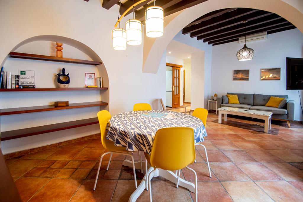 une salle à manger avec une table et des chaises jaunes dans l'établissement Apartamento Santa Maria Life, à Cadix