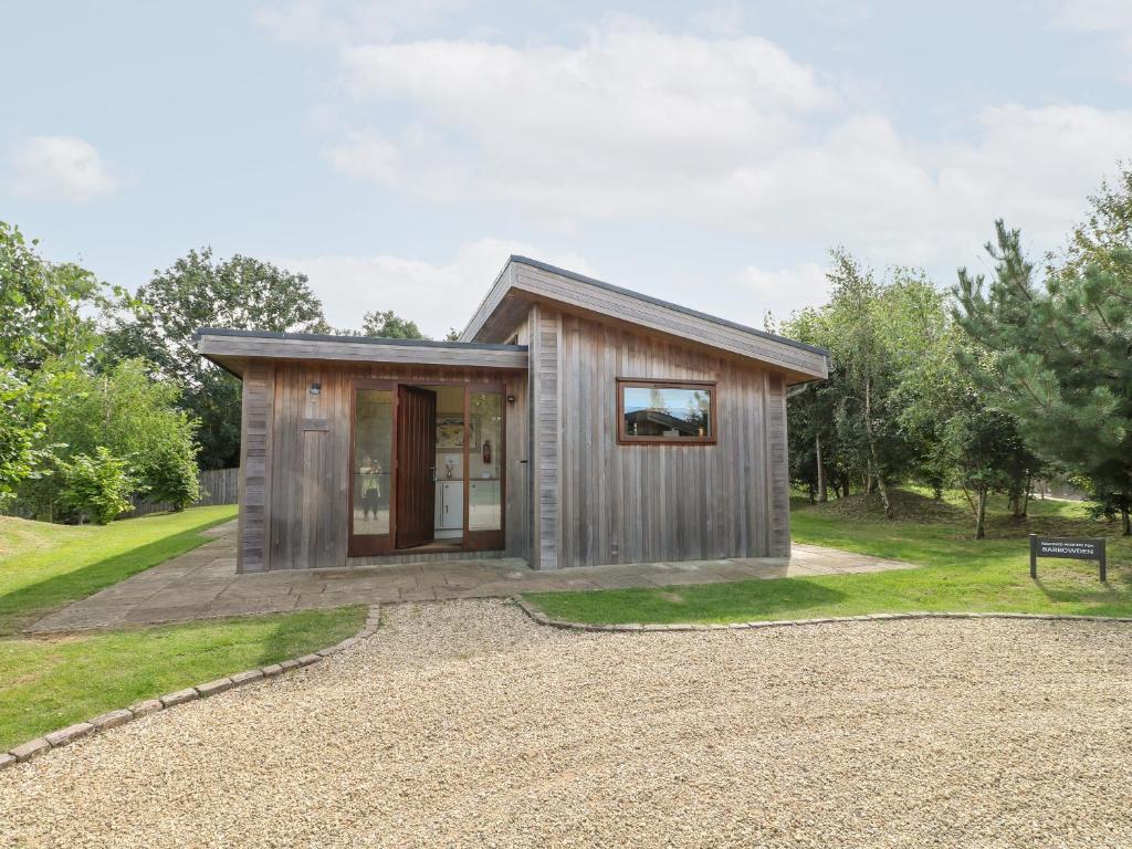 a tiny house in a park with a gravel driveway at Barrowden in Cottesmore