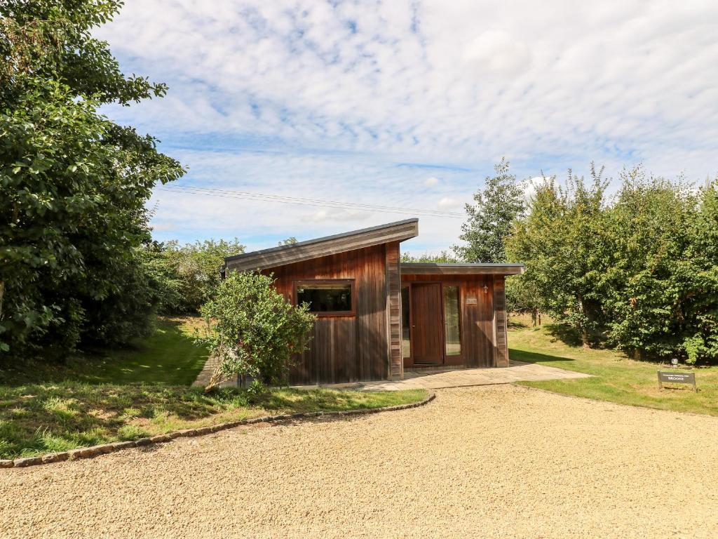 a small wooden shed with a gravel driveway at Brooke in Cottesmore