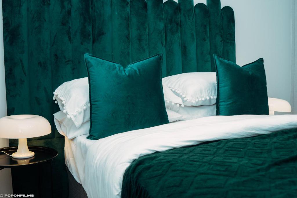 Dormitorio verde con cama con almohadas verdes en Green with Envy-Luxury Apartment- No Loadshedding, en Johannesburgo