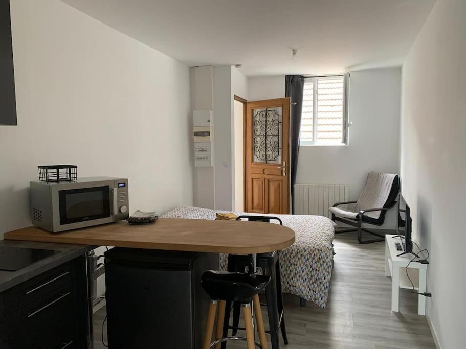 a small kitchen with a table with a microwave at Studio en centre ville d'Argentan in Argentan
