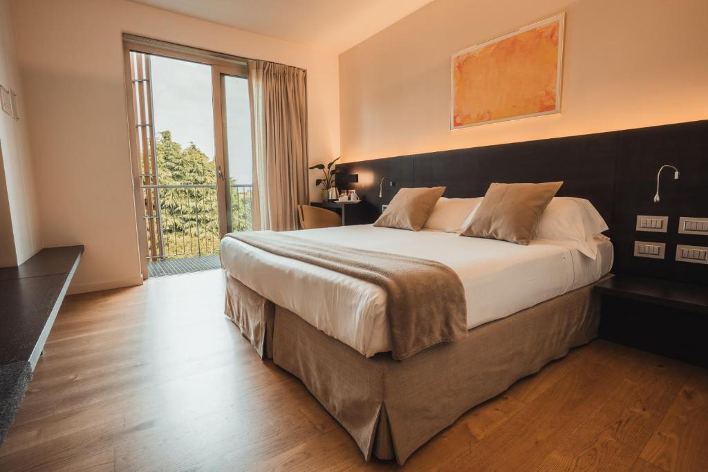 a bedroom with a large bed and a large window at Mod 05 Bike Hotel in Castelnuovo del Garda