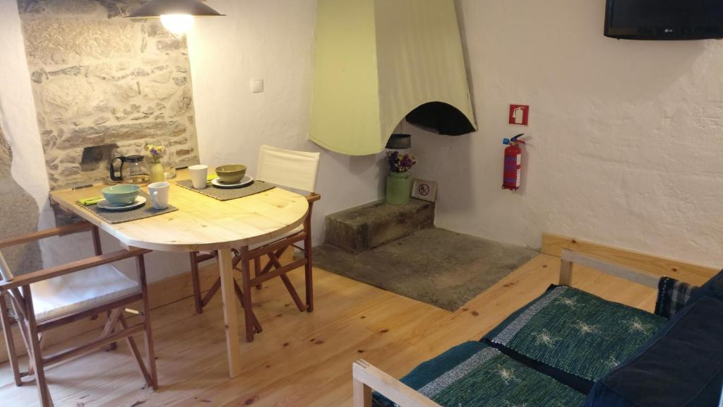 een kamer met een tafel en stoelen en een brandkraan bij Casinhas de S. Francisco T2 Azeitona by LovelyStay in Freixo de Espada à Cinta