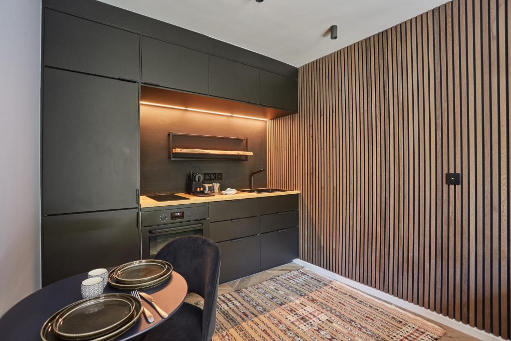 Zimmer mit einem Tisch und einer Küche mit einer Theke in der Unterkunft Studio in Neuilly Porte Maillot by Studio prestige in Neuilly-sur-Seine