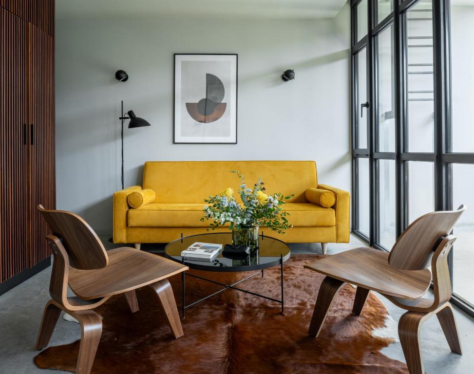 a living room with a yellow couch and two chairs at Lisbon Five Stars Alcântara Lofts in Lisbon