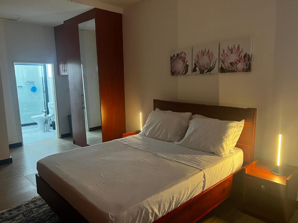 um quarto com uma cama e duas luzes em duas mesas em Smart Stay Eco Friendly AirBnB em Lusaka
