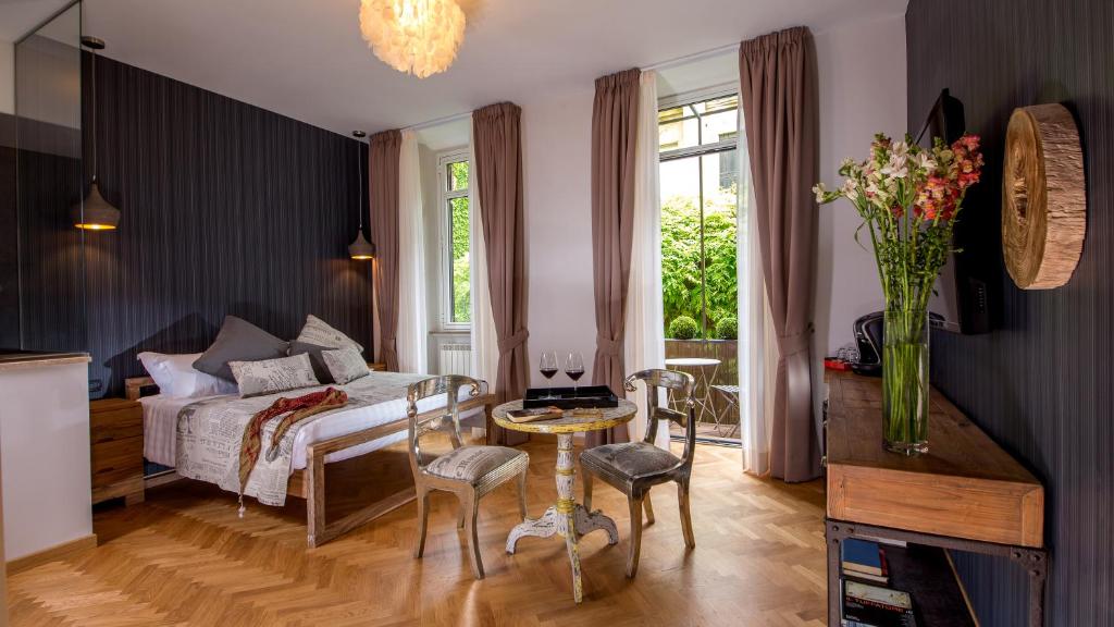 1 dormitorio con 1 cama, mesa y sillas en QT Suites Roma, en Roma