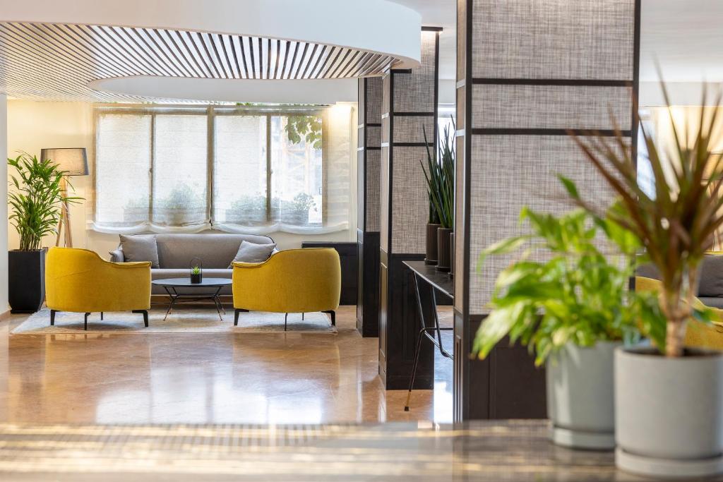 a lobby with yellow chairs and a couch at Caesar Premier Jerusalem Hotel in Jerusalem